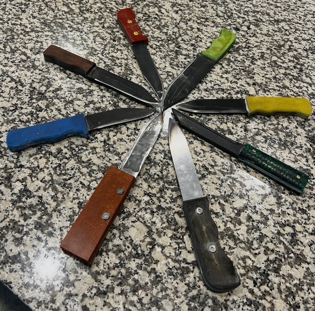 Collection of handmade knives arranged in a circle